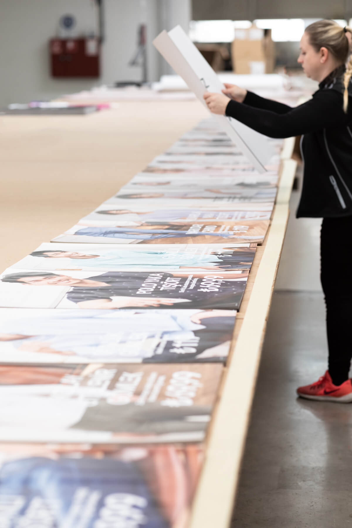 Woman packaging printed banners ready for fulfillment