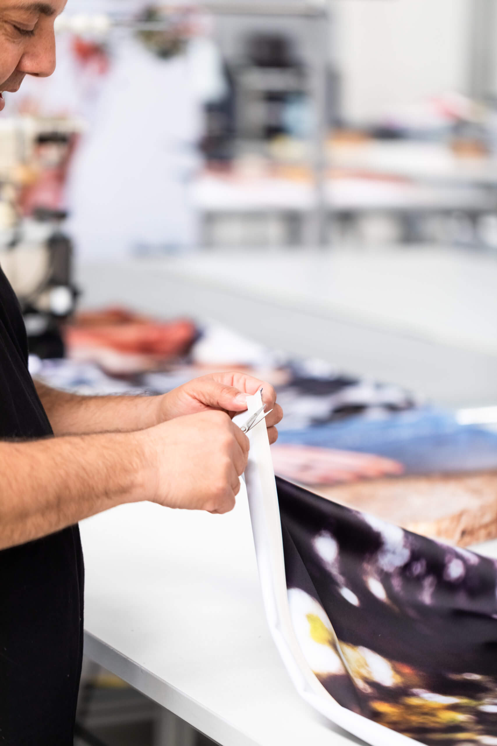 Man finishing off a fabric banner with scissors