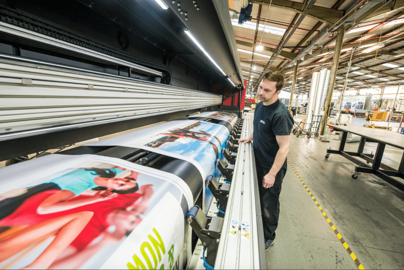 Mann kontrolliert die gedruckten POS-Materialien die gerade gedruckt werden